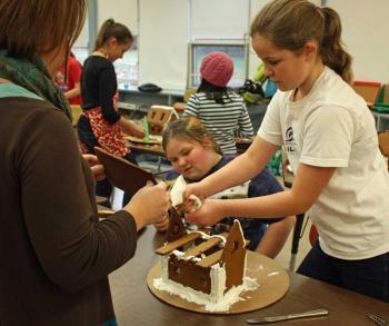 Art teacher Kirsten Andersen, left, is ready to help these students affix their roof. (Photo by Holly S. Edwards)