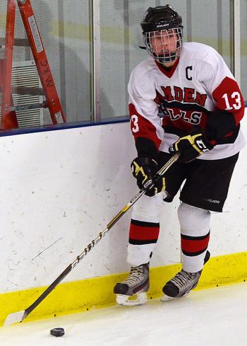 Camden Hills captian Calvin Robbins looks to clear the puck out of the Windjammer zone. (Photo by Ron Hawkes)