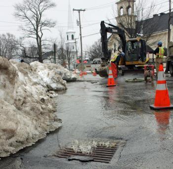 An adjacent storm drain is catching the runoff from the broken water main under Union Street in Camden Sunday morning. (Photo by Holly S. Edwards)