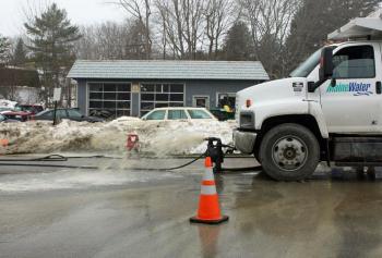 Water leaking from a broken pipe in Camden, flowing at 3,500 to 4,000 gallons per minute, is pumped out of a hole dug on Union Street by Maine Water crews Sunday. (Photo by Holly S. Edwards)