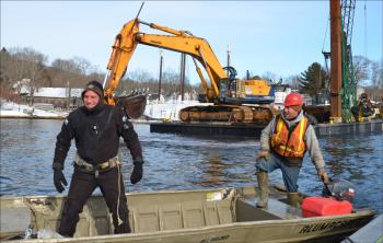 Toby Wincklhofer prepares to dive into Camden Harbor Jan. 11 to release line that had tangled with a tug's propeller. Jamie Dever takes him over to the spot in his skiff. (Photo by Lynda Clancy)