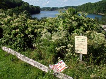 A sign at the old Upper Bridge Crossing last summer announces Coastal Mountains Land Trust's "Passy Greenway," the organization's vision of a trail connecting its nature preserves in the area. The "Train Rides," were the main attraction but may soon be relegated to a station further down the line. (Photo by Ethan Andrews)