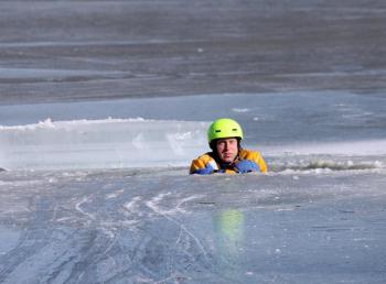 Rockland firefighter Mike Cole waits to be rescued during training on Chickawaukie Pond Saturday. (Photo by Holly S. Edwards)