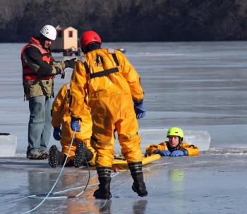 Rockland Fire Asst. Chief Adam Miceli, left, provides instruction during ice rescue training on Chickawaukie Pond in Rockland Saturday. (Photo by Holly S. Edwards)