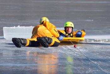 Firefighter Mike Cole is pulled onto the rescue sled during training Saturday on Chickawaukie Pond. (Photo by Holly S. Edwards)