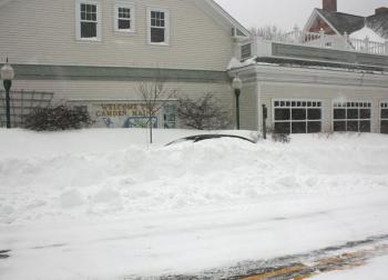 A car left parked on Elm Street in front of RiteAid is buried in snow. (Photo by Holly S. Edwards)