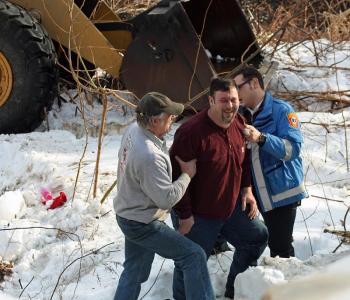Tracy Harford is checked out by Camden First Aid after he went down an embankment and was ejected from the front-end loader he was driving. (Photo by Holly S. Edwards)