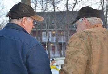 Dwight Henry and Jim Stewart, owner of Stewart's Towing, in Orrington, confer about how to haul the loader up. (Photo by Lynda Clancy)