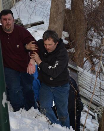 Steve Laite, right, walks up through the snow with an injured Tracy Harford and others. (Photo by Lynda Clancy)