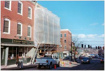 BELFAST - Scaffolding covers Maine Farmland Trust building during renovations that included the addition of a dormer in the rear of the building, a common space-making modification to shed-roofed buildings downtown. BELFAST - Scaffolding covers the front of a Main Street building owned by Maine Farmland Trust. (Photo by Ethan Andrews)
