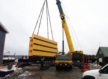 One of two dock fenders custom built for use with a nuclear-powered submarine is loaded onto a barge Thursday at the former Belfast Boatyard property, now part of Front Street Shipyard. (Photo by Ethan Andrews)