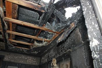 A wider view of the back of the home where fire burned through the roof. (Photo by Holly S. Edwards)