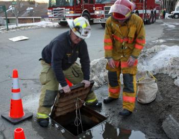 Setting up for Sunday night's burning of Lotus required running a line under Conway Road via a drainage culvert. (Photo by Holly S. Edwards)