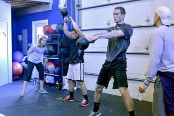 Local athletes Drew Townsend, right, and Daniel Hendricks are spotted and scored by coaches Jason Foster, far right and Teel Foster, owners of the CrossFit Crossover Box in Thomaston during the March 9 Throwdown. (Photo by Ron Hawkes)