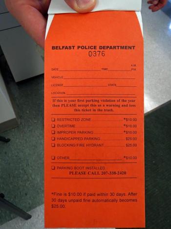 Belfast's new, bright orange parking ticket is self-mailing, eliminating the excuse "I couldn't find an envelope to mail the fine." (Photo by Erica Thoms)