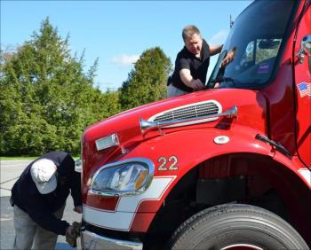 Allen Mitchell and Bill Lane make sure the trucks are spit and polished for the parade. (Photo by Lynda Clancy)