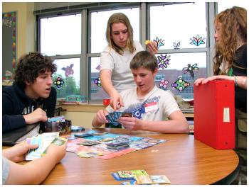 Jesse Perry, center, standing, had played the card-based trading game Pokemon for years at the Game Loft but had never led a session until he volunteered for the Mount View program. (Photo by Ethan Andrews)