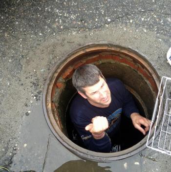 Camden Asst. Fire Chief Andrew Lowe reports his findings, 'Can't reach the ducklings' from inside the storm drain catch basin Friday. (Courtesy Steve Pixley)