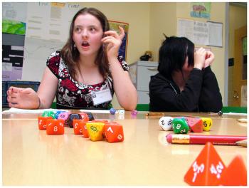 Samantha Sullivan, left, reacts during a session of the role-playing game Pathfinder. Sullivan and fellow middle schooler Lille Gates, right, are part of a new group of students from Western Waldo County that has been able to tap into the Game Loft since the Belfast-based after school program launched its satellite program at Mount View School last fall. (Photo by Ethan Andrews)