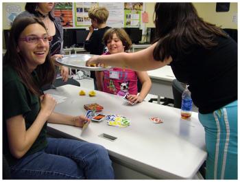 Mount View students Brandy Foster, left, Emily Kendall, center, and Morgan Taylor grab a snack of orange wedges during a game of Uno. This group included students from grades 3 through 11 in a scene where multi-age groups are common. (Photo by Ethan Andrews)