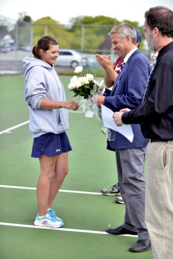 Oceanside senior Kasie Waters receives a carnation from principal Tom Forti as assistant principal Bill Gifford looks on. (Photo by Ron Hawkes)