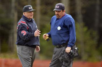 Two of the KLW's finest, Dennis Wooster, left, and Paul Berube talk over a call on the field. (Photo by Ron Hawkes)