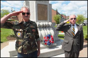 Francis Farley and Janes Brannan salute after laying a wreath in honor of those who gave their lives in war.