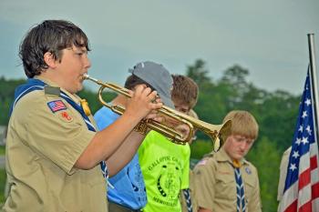 Troop 254 Boy Scout Jaden Abruzese plays taps to honor Paul R. Galipeau. (Courtesy Leanne M. Robicheau)