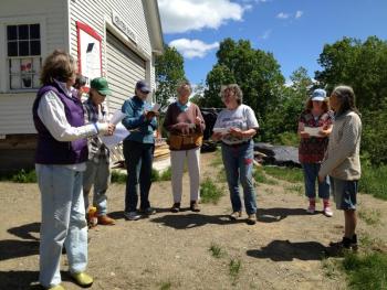 Members of the crew building the sheds for the open-air museum next to the Lincolnville Community Library listen to instructions on their first day on the job. From left, Julie Turkevich, crew leader Sandy Shute, Greta Gulezian, Jill Harvey, Louisa Gerstenberger, Historical Society Chairman Diane O’Brien, Barbara Biscone and Cindy Dunham. (Photo by Sheila Polson)