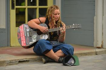 Autumn is from Oregon, here on a schooner she is working on. Playing some folk and blues for tips, sounded great on the guitar as well as vocals. (Photo by Ron Hawkes)