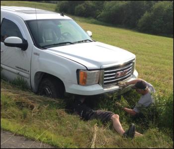 Camden Exxon attaches cables to the truck to haul it out of the ditch.
