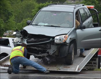 Steve Laite, owner of Camden Exxon, secures the Toyota to the truck bed.(Photo by Lynda Clancy)