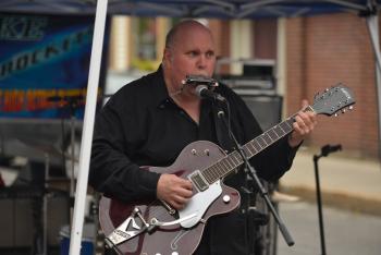 Playing a little harp and guitar for the Juke Rockets. (Photo by Ron Hawkes)