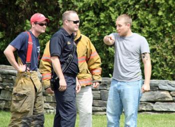 Vernon Kvorjak, far right, of Owls Head, talks to Rockport Fire Chief Jason Peasley and firefighters about the accident that destroyed his motorcycle Monday. (Photo by Holly S. Edwards)