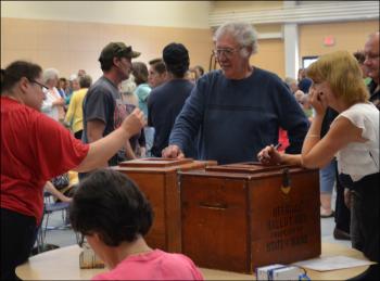 Casting ballots into the wooden ballot box, and constant fixture at Lincolnville Town Meeting. (Photo by Lynda Clancy)