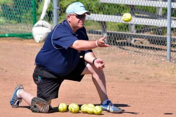 Oceanside coach Rusty Worcester does soft toss with his batters before the game. (Photo by Ron Hawkes)
