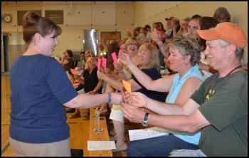 Tax Collector Rosanna Bowman hands paper ballots to Hope residents at annual town meeting June 17. They will mark the ballots, indicating support or opposition to cutting a proposed compensation increase for the fire chief and then drop the ballot into a cardboard box. (Photo by Lynda Clancy)