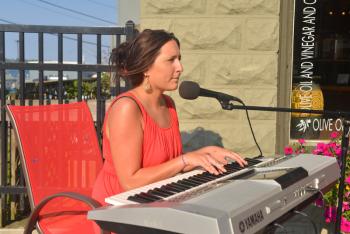 Kate Paquin plays keyboards and sings outside Fiore, located at the end of Main Street next to the ferry terminal. (Photo by Ron Hawkes)