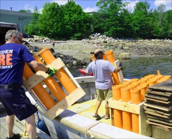 Camden Fire Chief Chris Farley and Chief Deputy Harbor Master Jim Leo load up the fireworks on the gunboat. (Photo by Lynda Clancy)