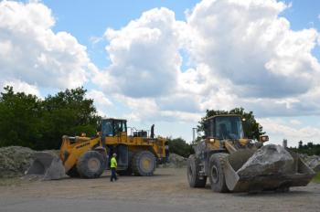 By 2 p.m., Dragon Cement backhoes were placing rocks near the entrance of their quarry-lined property to discourage parking and trespassing. (Photo by Lynda Clancy)