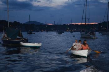 By dusk, people were rowing and paddling into the harbor, settling within a 450-foot perimeter from the barge. (Photo by Lynda Clancy)