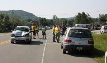 Jean Curtin's crumpled 2004 Subaru is about to be towed off Route 17 in Rockport Wednesday morning, while Police Chief Mark Kelley talk to Alyce Delfino alongside her pickup truck in the parking lot of Green Thumb. (Photo by Holly S. Edwards)