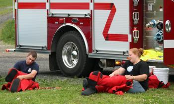 Thomaston firefighters Colby Miles and Jessica Gunn don survival suits in prepration for swimming to rescue victims in the river. (Photo by Holly S. Edwards)