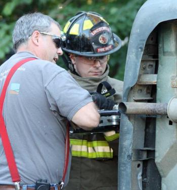 Steve Young of Lincolnville demonstrates how to use a hydraulic spreader to open the tailgate on an overturned van. (Photo by Holly S. Edwards)