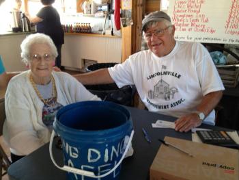 Longtime Lincolnville Improvement Association member Peg Miller, left, and Vice President Brian Cronin sell raffle tickets.