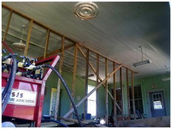 The interior of the old school house, and at right a hydraulic jack system used during the transport. (Photo by Ethan Andrews)