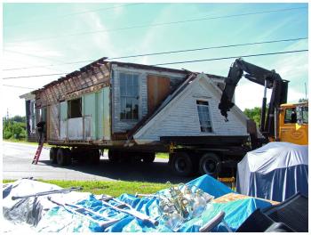 A truck pulling the old school house pauses on Route 137 near the Knox town office. (Photo by Ethan Andrews)