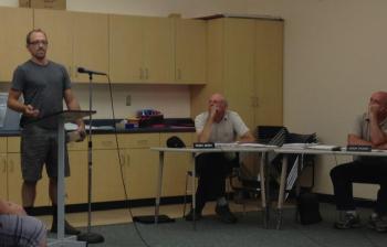 Gus Johnson, of Lincolnville, addresses Lincolnville selectmen Aug. 12, raising concern about the noise produced from frequent displays of fireworks. Seated, from left, are selectmen Rosey Gerry and Jason Trundy. (Photo by Lynda Clancy)
