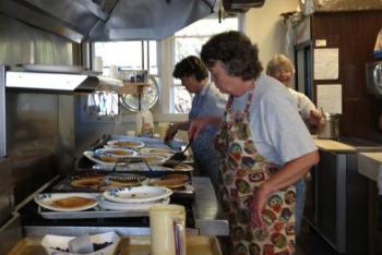 Diane O’Brien flips blueberry pancakes at the wingding. (Photo by Sheila Polson)