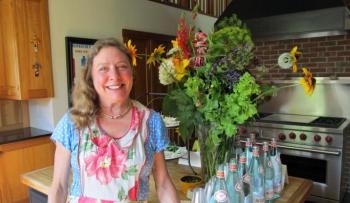 Chef/Caterer Laura Cabot in the Morse kitchen surrounded by flowers from her own garden. Photo by Kay Stephens
